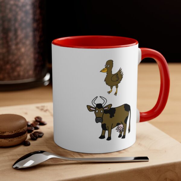 Brown Chicken Brown Cow White Coffee Mug With Red Handle And Interior – Right Hand View – On A Table With A Spoon.