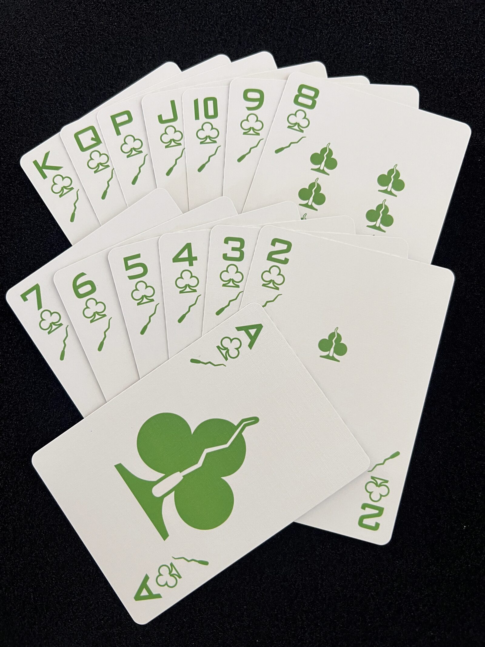 Fan of the Ikonology clubs suit in green, each card also marked with the tarot wands symbol
