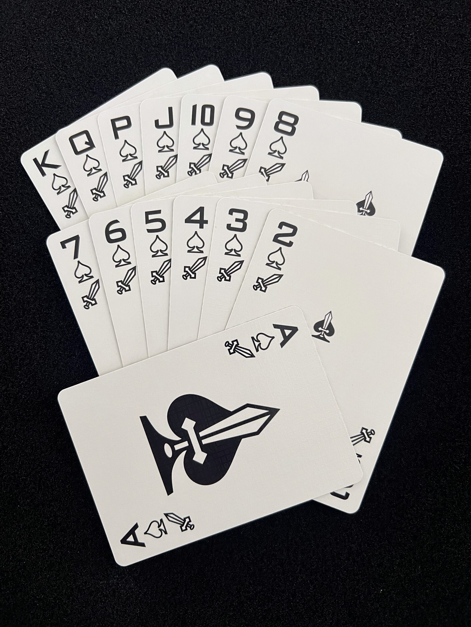 Fan of the Ikonology spades suit in black, each card also marked with the tarot swords symbol
